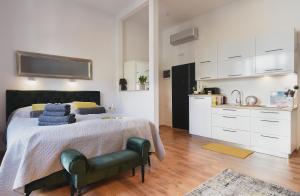 ein Schlafzimmer mit einem Bett mit blauen Kissen und eine Küche in der Unterkunft E&F Luxury Apartments in Pula