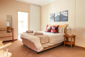 um quarto com uma cama grande e almofadas em Kunje Guesthouse em Op-die-Berg