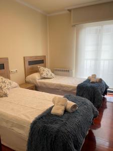 a bedroom with two beds with towels on them at Alojamiento Apostol 1 in Melide
