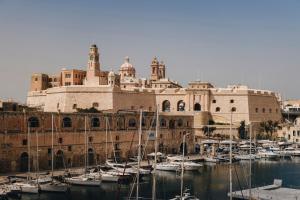 um grupo de barcos em um porto em frente a um edifício em Dock 1 Boutique Hotel em Cospicua