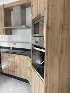 a kitchen with a stove and a microwave at Alojamiento Apostol 2 in Melide +3 photos