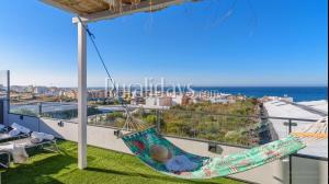 a hammock on a balcony with a view of the ocean at Apartamento y Estudio Torre Vigía in Morche