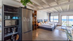 Zimmer mit einem Kühlschrank und einem Schlafzimmer mit einem Bett. in der Unterkunft Apartamento y Estudio Torre Vigía in Morche