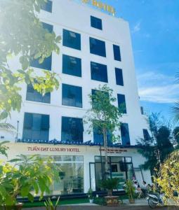 un edificio blanco con un cartel que lee el mejor hotel de lujo de Titán en Tuấn Đạt Luxury FLC Sầm Sơn en Sầm Sơn