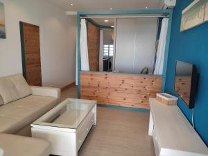 a living room with a couch and a tv at Apartamento y Estudio Torre Vigía in Morche
