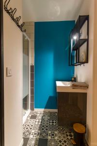 a bathroom with a sink and a blue wall at Le petit Studio proche gare in Flers