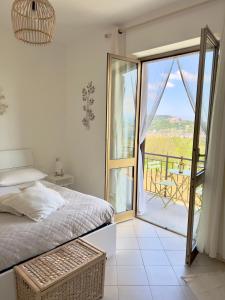 a bedroom with a bed and a large glass door at Vista sul Forte in Gavi