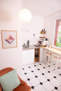 een keuken met een zwart-wit geruite vloer bij Charmant Studio au coeur de Jaurès in Belfort