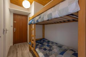 1 Schlafzimmer mit 2 Etagenbetten und einer Tür in der Unterkunft Terrasse des Lupins in Embrun