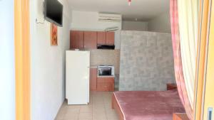 a small kitchen with a refrigerator and a table at Villa Christina Sea Side in Hanioti