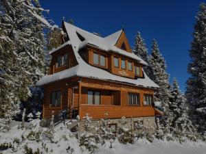 a log cabin with snow on the roof at Chata Olina in Oravice