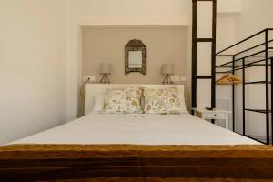 Schlafzimmer mit einem großen weißen Bett und einem Spiegel in der Unterkunft Increíble Apto 3º San Miguel CentroCatedral+Parking+Wifi in Granada