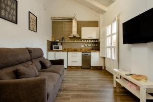 ein Wohnzimmer mit einem Sofa und einer Küche in der Unterkunft Increíble Apto 3º San Miguel CentroCatedral+Parking+Wifi in Granada