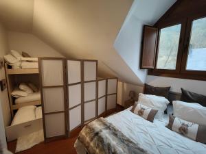 Schlafzimmer im Dachgeschoss mit einem Bett und einem Etagenbett in der Unterkunft La Moleta Canfranc in Canfranc