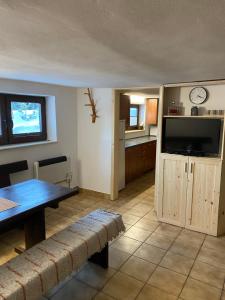 a living room with a table and a television at Chata Olina in Oravice