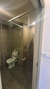 a bathroom with a glass shower with a toilet at Aeropod [5B]/Near Airport / 2 Queen Bed/ Netflix/Free Parking in Kota Kinabalu