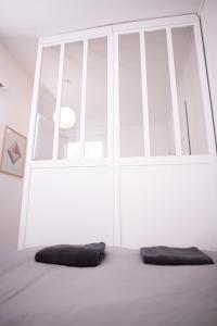 een bed met 2 kussens voor een raam bij Charmant Studio au coeur de Jaurès in Belfort