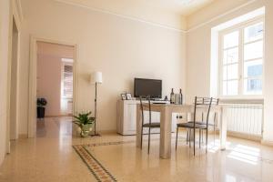 sala de estar con mesa con sillas y TV en Corner Cavour Apartment en Sassari
