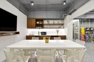 uma sala de jantar com uma mesa branca e cadeiras em Tiang Studio em Banguecoque