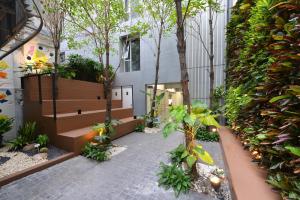 a garden with benches and trees in a building at Tiang Studio in Bangkok