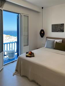 sypialnia z dużym łóżkiem i dużym oknem w obiekcie Portobello Boutique Hotel w mieście Mykonos