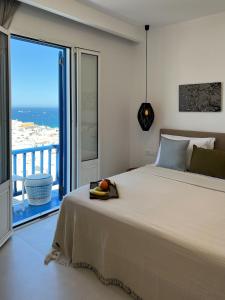 a bedroom with a large bed and a large window at Portobello Boutique Hotel in Mikonos