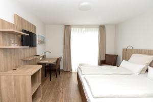 ein Hotelzimmer mit 2 Betten und einem Schreibtisch in der Unterkunft Hotel Jesteburger Hof in Jesteburg