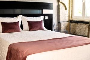 a bedroom with a large bed with red and white pillows at Residencial Portas do Sol in Valença