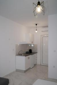 a white kitchen with a sink and a counter at Ktima Ayia Marina in Amalias