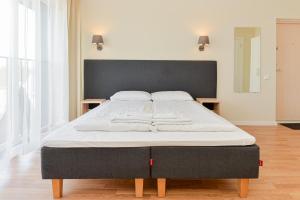 uma cama grande num quarto com uma cama grande sidx sidx em Liepų apartamentai em Palanga