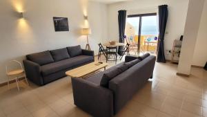 a living room with two couches and a table at Apt con piscina La Laja, La Restinga (El Hierro) in La Restinga