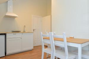 - une cuisine avec une table et des chaises dans la chambre dans l'établissement Liepų apartamentai, à Palanga