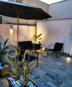 a patio with two chairs and a table and an umbrella at Il Civico 2 in Bari