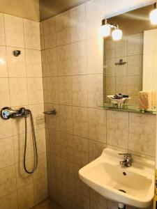 a bathroom with a sink and a shower with a mirror at Kirkos Apartments in Kamariotissa