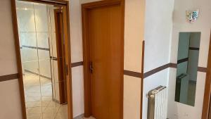 uma casa de banho com uma porta de madeira e uma porta de vidro em Appartamento Canalotto 65 2 piano em Realmonte