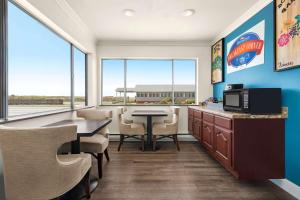 una sala d'attesa con tavolo, sedie e finestre di Baymont by Wyndham Fort Bragg a Fort Bragg