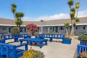 a group of blue benches in front of a building at Baymont by Wyndham Fort Bragg in Fort Bragg