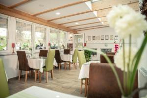 een eetkamer met tafels, stoelen en ramen bij Spreewald Pension Tannenwinkel in Lübbenau