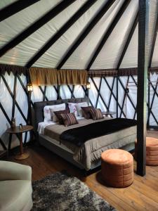 a bedroom with a bed in a tent at Yurt Tree, romântico e confortável, experiência unica in Jacutinga