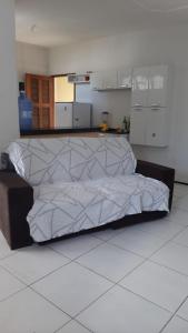 a large bed in a room with a kitchen at Cantinho arretado da Peste - Casa in Aquiraz