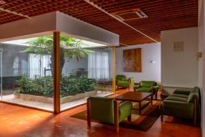 ファティマにあるFlag Hotel Fatima Casa Das Irmas Dominicanasの緑の椅子とテーブルが備わる待合室