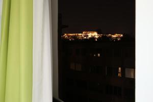 Athens Starlight Hotel في أثينا: اطلالة على المدينة ليلا من النافذة