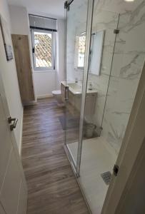 a bathroom with a shower and a sink and a toilet at Apartamentos Casa do Pan in Corme-Puerto