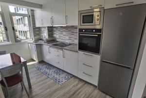 a kitchen with white cabinets and stainless steel appliances at Apartamentos Casa do Pan in Corme-Puerto +22 photos