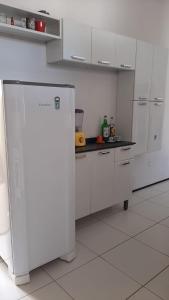a kitchen with white cabinets and a white refrigerator at Cantinho arretado da Peste - Casa in Aquiraz