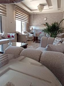 a large living room with couches and a table at AlQimah Hotel Apartments in Amman