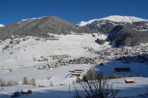 a small town on a snowy mountain with snow covered mountains at Apart Padöller in Nauders