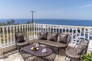 balkon z krzesłami i stołem z misą owoców w obiekcie Amarie House with Sea View & Sunset View w mieście Oia +32 zdjęcia