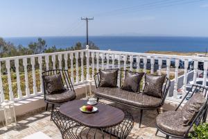 patio z krzesłami i stołem oraz oceanem w obiekcie Amarie House with Sea View & Sunset View w mieście Oia