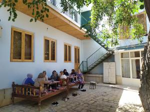 a group of people sitting on a bench in a building at Minorai Xurd in Bukhara